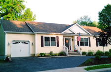 This long ranch home with its recessed front entry, stately sloped driveway and reverse front gable gives an elegant look from the street. Landscaping enhances the home which includes a circular driveway.